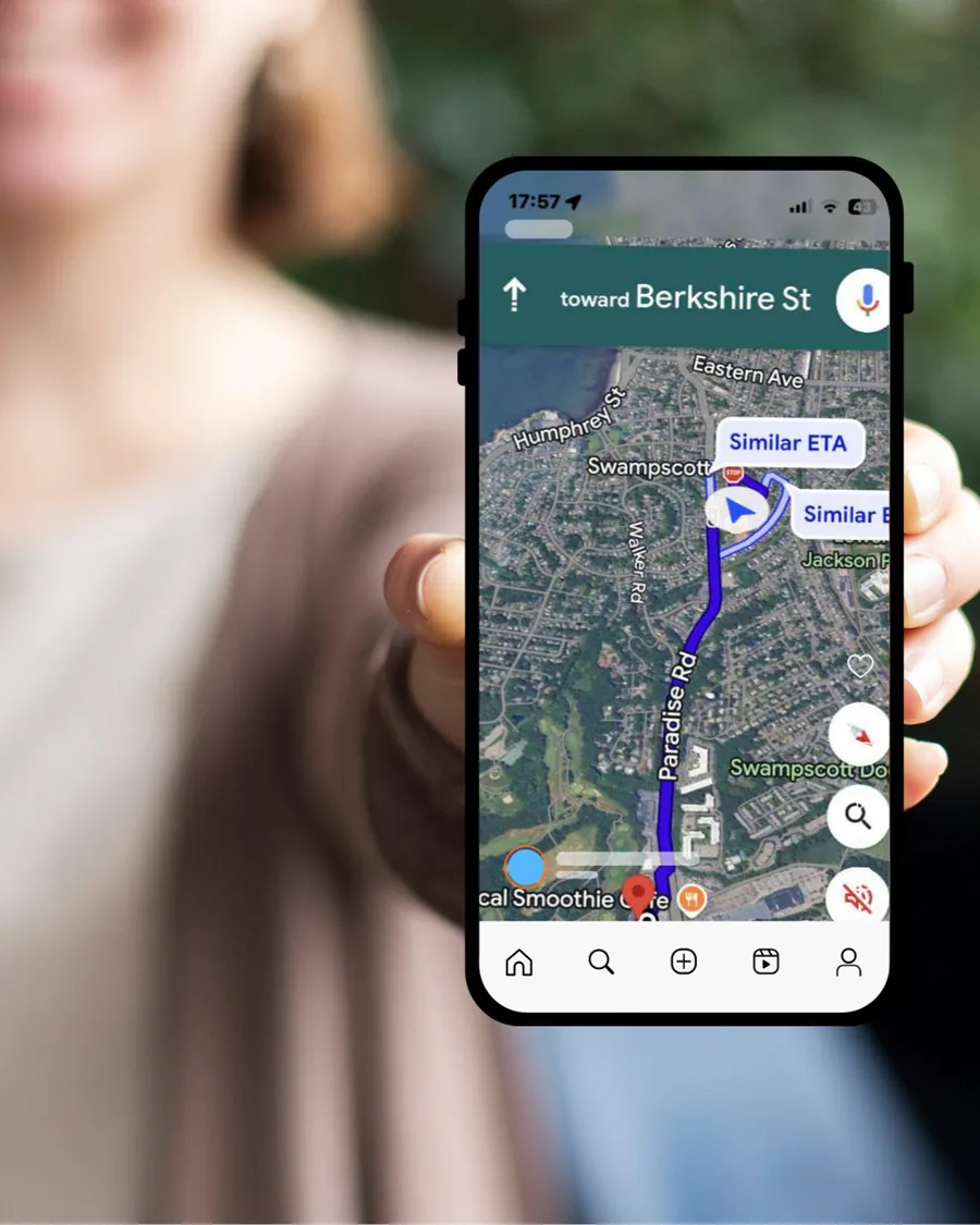 A phone held up showing a map of Swampscott, Massachusetts with Humphrey Street and Paradise Road, and a route marked toward a local business