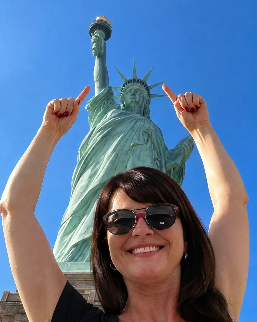 Maida White at the Statue of Liberty, pointing up at it with both hands, on the day she arrived in the United States